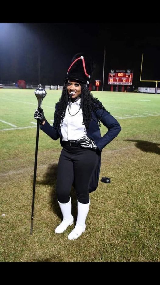 student drum major in full uniform on football field