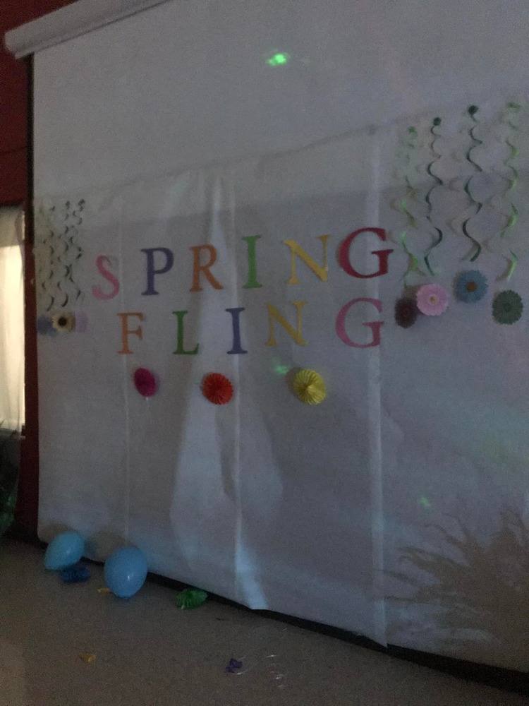 white curtain with spring fling in colorful letters with balloons